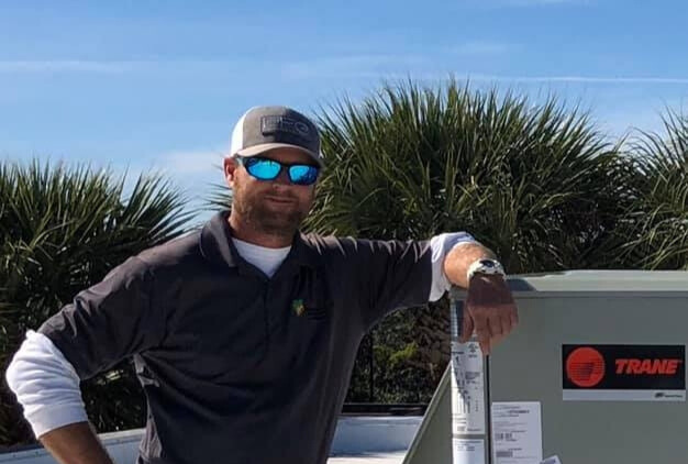 Service technician working outdoors near home HVAC equipment