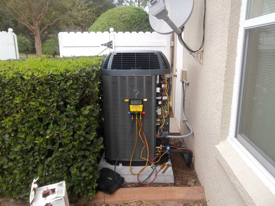 Outdoor air conditioning condenser next to home