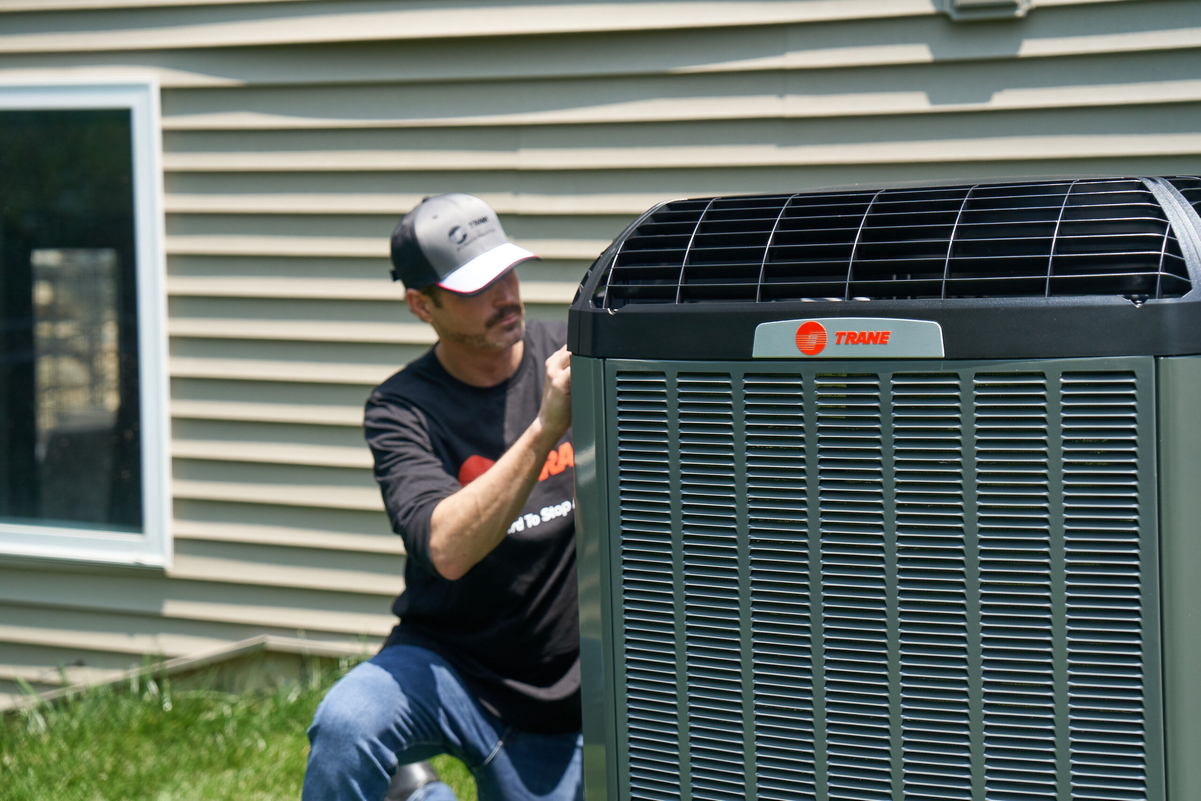 HVAC technician working on outdoor air conditioning unit